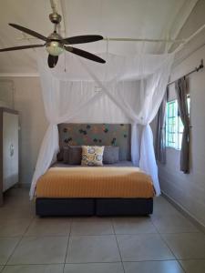 Acacia Cottage في ماون: غرفة نوم بها سرير ومروحة سقف