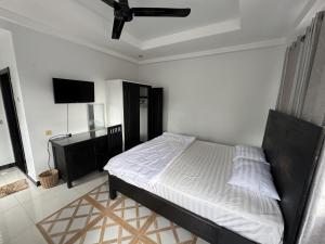 a bedroom with a bed and a flat screen tv at Villa de Sancho in Phumĭ Réach Born (2)
