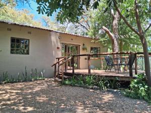 Acacia Cottage في ماون: شرفة منزل عليه مقعد