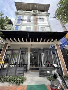 a white building with a black awning on it at Villa de Sancho in Phumĭ Réach Born