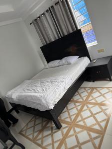 a bedroom with a bed with a bed frame and a window at Villa de Sancho in Phumĭ Réach Born