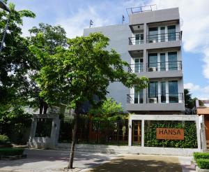 un edificio con un cartello della farmacia di fronte di Hansa Bangkok House a Bangkok