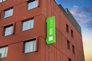 a building with a green sign on the side of it at ibis Styles Warszawa Airport in Warsaw