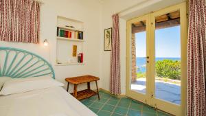 a bedroom with a bed and a view of the ocean at Futura anima sarda, villa sul tramonto con piscina privata in Costa Paradiso +43 photos
