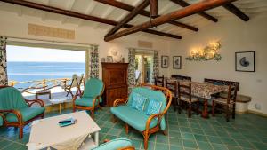 a room with a dining room with a table and chairs at Futura anima sarda, villa sul tramonto con piscina privata in Costa Paradiso