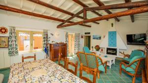 a living room with a table and chairs at Futura anima sarda, villa sul tramonto con piscina privata in Costa Paradiso