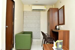 a room with a green chair and a desk and a heater at Raj Gharana in Raipur