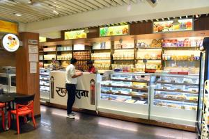 a man standing at a food counter in a store at Raj Gharana in Raipur