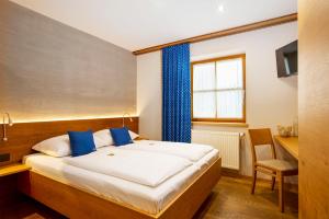Un dormitorio con una cama y un escritorio y una ventana. en Winzerhof Kiss, en Jois