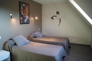 twee bedden in een kamer met een foto aan de muur bij Villa Residence Kersaliou in Roscoff