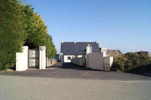 een wit huis met een gebouw op de achtergrond bij Villa Residence Kersaliou in Roscoff
