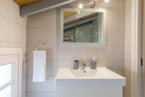 a bathroom with a white sink and a mirror at Sunny Skylight Loft! in Ágios Rókkos