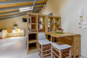 a room with a desk with stools and a book shelf at Sunny Skylight Loft! in Ágios Rókkos
