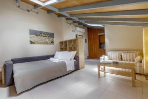 a bedroom with a bed and a couch and a table at Sunny Skylight Loft! in Ágios Rókkos