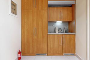 a kitchen with wooden cabinets and a sink at Sunny Skylight Loft! in Ágios Rókkos