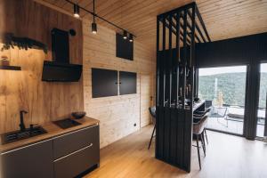 a kitchen with wooden walls and a dining room at View Point Maguri in Măguri