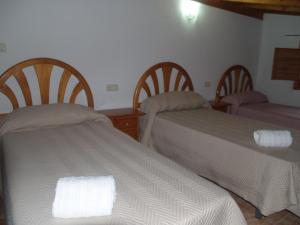 a bedroom with two beds and two chairs with towels at Apartamento2 San Cristobal cerca de Cuenca in Colliguilla