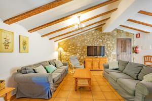 a living room with couches and a tv at El Molinet del Governador- Apartamentos Rurales in Guadalest