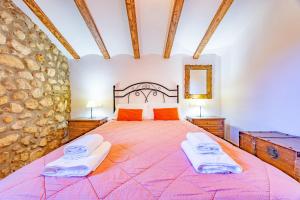 a bedroom with a large bed with two towels on it at El Molinet del Governador- Apartamentos Rurales in Guadalest +95 photos