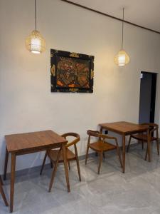 three tables and chairs in a room with lights at Bayedan Homestay in Badung
