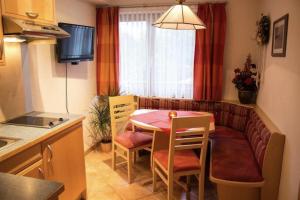 a small kitchen with a table and chairs in a room at Pizzeria Prosser - Appartements in Dienten am Hochkönig