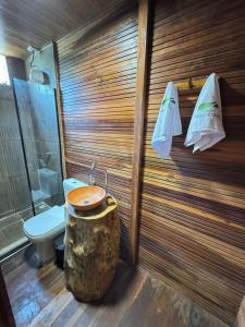 a bathroom with a toilet and a wooden wall at Hotel e Restaurante Tribo Combú in Belém +11 photos