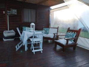 a porch with two chairs and a table and chairs at Los abelos in Gualeguaychú