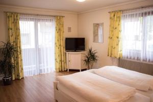 a bedroom with a bed and a flat screen tv at Pizzeria Prosser - Appartements in Dienten am Hochkönig