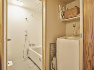 ein kleines Badezimmer mit Waschmaschine und Trockner in der Unterkunft TABiE in Izumo + 13 Fotos