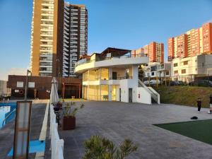 un edificio con piscina frente a algunos edificios en Departamento 1 ambiente brisas del sur 2, en Iquique