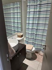 Un baño con lavabo, inodoro y espejo. en Departamento 1 ambiente brisas del sur 2, en Iquique