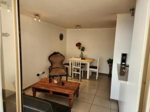 una sala de estar con una mesa y una silla en Departamento 1 ambiente brisas del sur 2, en Iquique