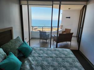 Un dormitorio con una cama y vista al mar. en Departamento 1 ambiente brisas del sur 2, en Iquique 37 fotos más