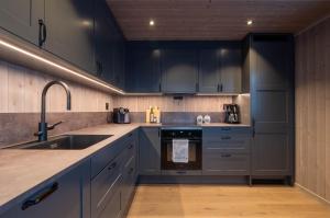 Una cocina con gabinetes azules y un fregadero. en Hoven Lodge,  37 fotos más