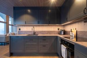 Una cocina con gabinetes negros y un fregadero. en Hoven Lodge, 