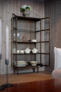 Un estante con platos y platos encima en una habitación. en Hoven Lodge, 