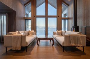 a living room with two couches and a large window at Hoven Lodge in Vik