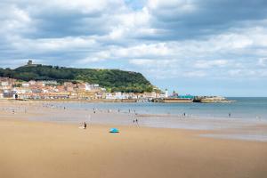 a group of people on a beach near the water at Seascape - Fantastic Location with Sea Views! in Scarborough