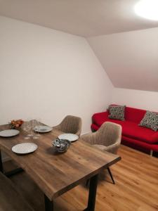 a dining room with a wooden table and a red couch at Schöne Ferienwohnung in Schwerte Central in Schwerte