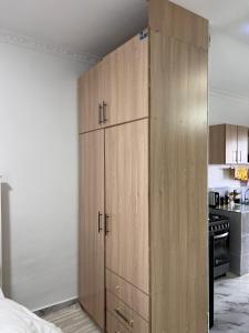 a large wooden cabinet in the corner of a kitchen at Studio in Nanyuki with Mount Kenya Views in Nanyuki +2 photos