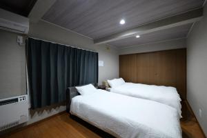 a bedroom with two beds and a large window at Toko92 in Asahikawa