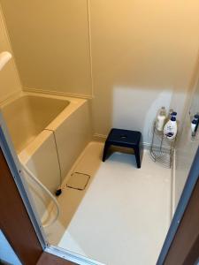 a small bathroom with a tub and a black stool at Toko92 in Asahikawa +27 photos