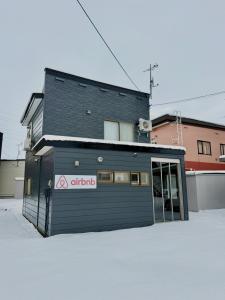 a black building with a sign on the side of it at Toko92 in Asahikawa