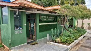 Un edificio verde con un cartel que dice "un gato blanco". en Hotel Pousada Casa Verde, en Cordisburgo