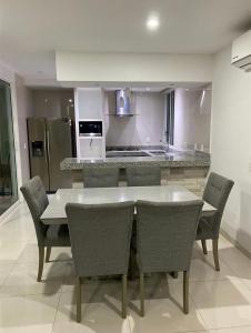 cocina con mesa, sillas y barra en Casa Hannia 30 huéspedes Cerca de la playa Alberca, en Acapulco