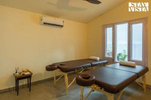 デヘラードゥーンにあるStayVista at Everdale with Heated Pool, Pet friendly, Bathtubのマッサージテーブル2台と窓が備わる客室です。 +64枚の写真