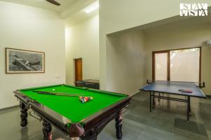 デヘラードゥーンにあるStayVista at Everdale with Heated Pool, Pet friendly, Bathtubのビリヤード台付きのリビングルーム