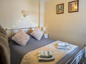 阿伯加文尼Trinity Cottage的卧室里有一张床，床上放着两条毛巾。