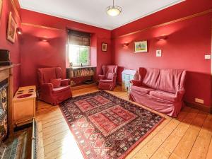 un salon avec des murs rouges et des meubles rouges dans l'établissement Kirkdale, à Kirkton