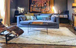 ein Wohnzimmer mit einem blauen Sofa und einem Tisch in der Unterkunft 3 Bedroom Gorgeous Home In Arjuzanx in Arjuzanx